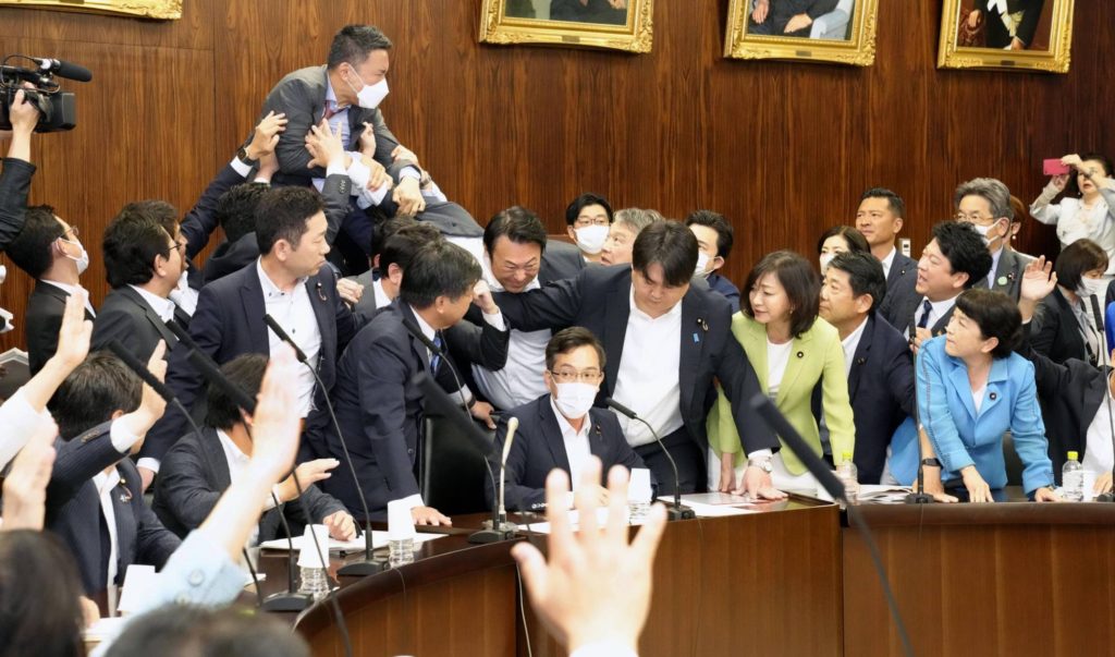 Los miembros del partido de oposición gritan mientras los legisladores de la coalición gobernante intentan someter a votación un controvertido proyecto de ley de inmigración en una reunión del comité de la Cámara Alta 
