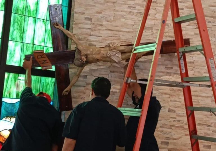 Los trabajadores de la UCA desmontan el Cristo antes de que sea confiscado por la policía orteguista.